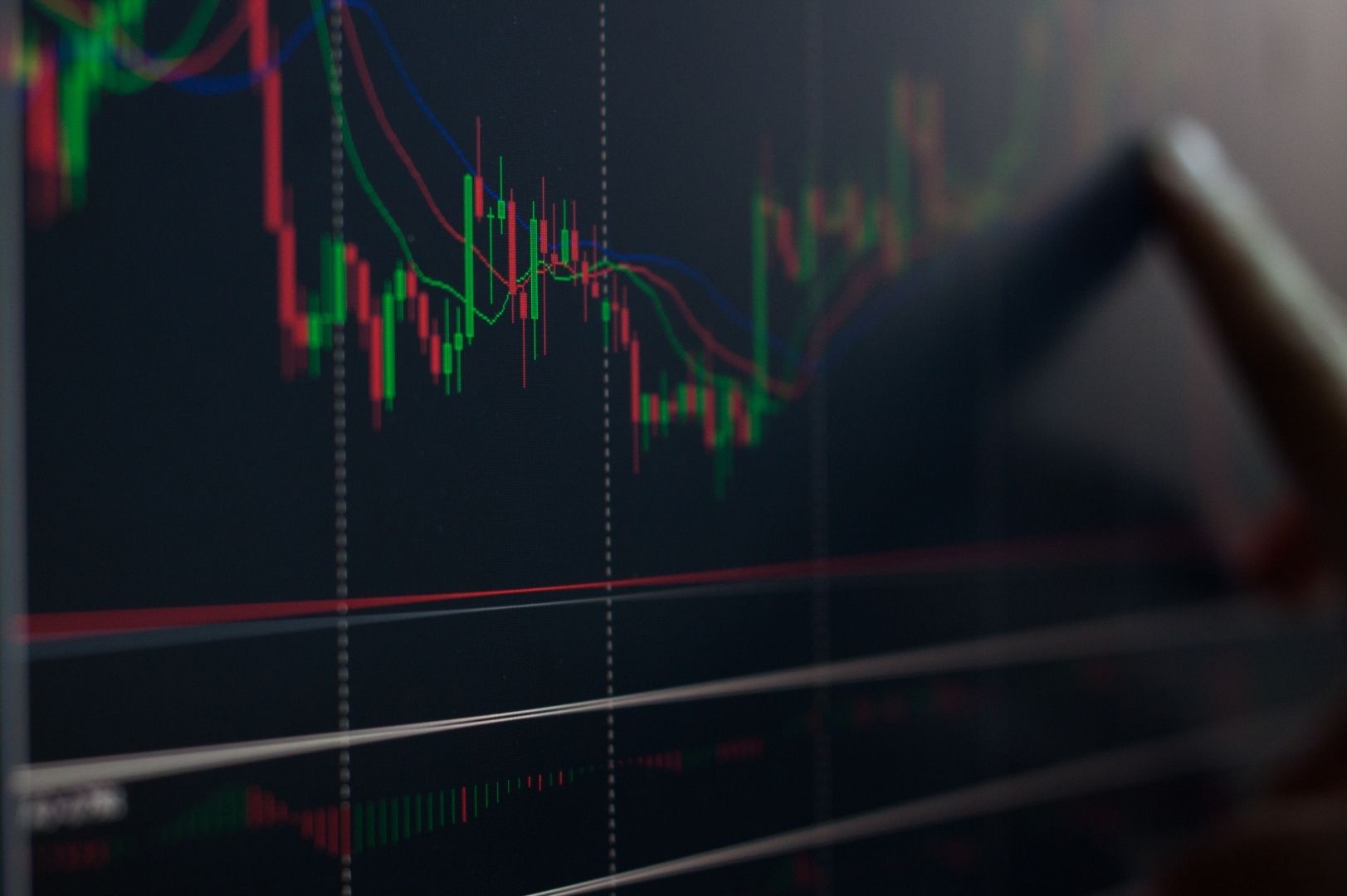 Extreme close-up of a digital candlestick chart on a screen, showing price action and multiple moving average lines.