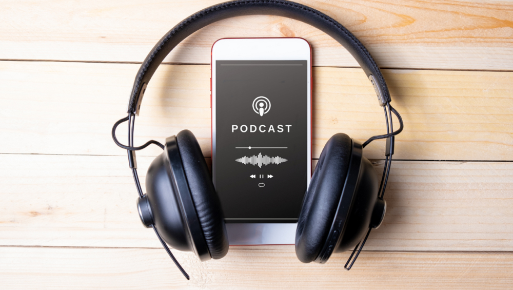 Earphones and smartphone displaying a podcast screen