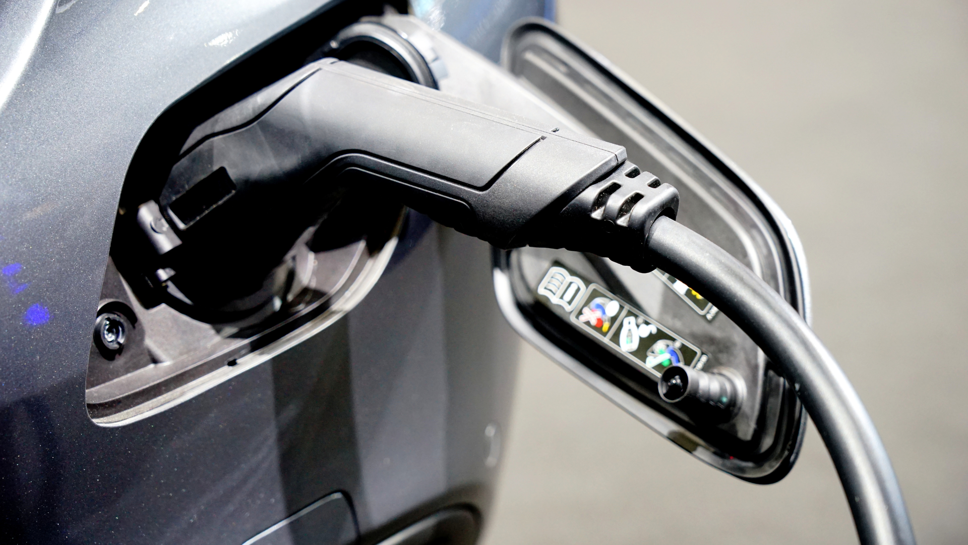 Electric vehicle charging plug connected to a car’s charging port.