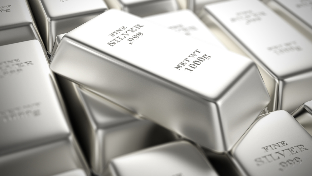 Close-up pile of stacked silver bullion bars (1000g, Fine Silver .999) with selective focus.
