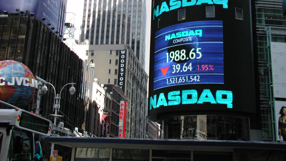 The massive NASDAQ Composite electronic billboard in Times Square, New York City, displaying stock market data.