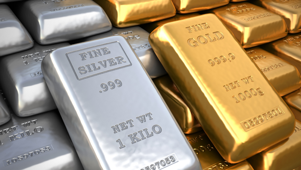 Two prominent kilogram bars of metal, one labeled "FINE SILVER" and the other "FINE GOLD," resting on a pile of similar bullion bars.