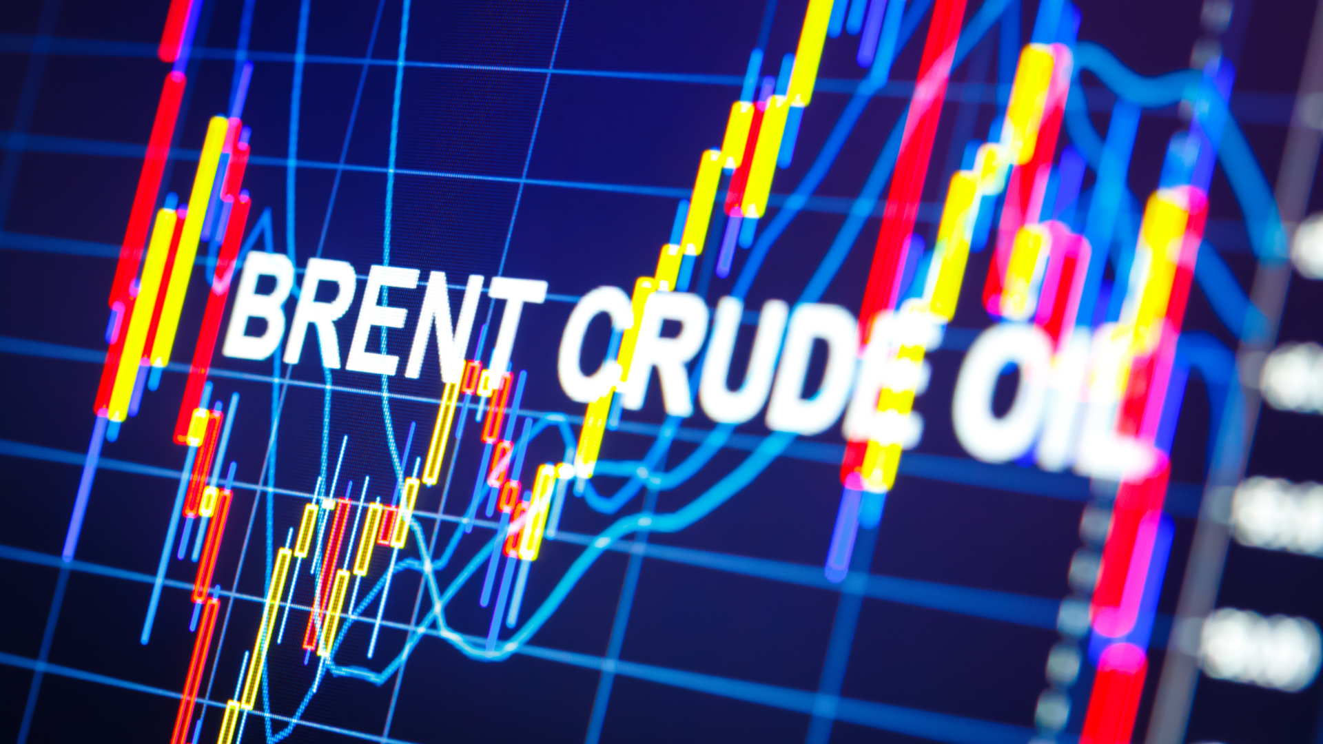 Close-up of a digital screen showing a dynamic financial chart with red and yellow lines and the bold text "BRENT CRUDE OIL."