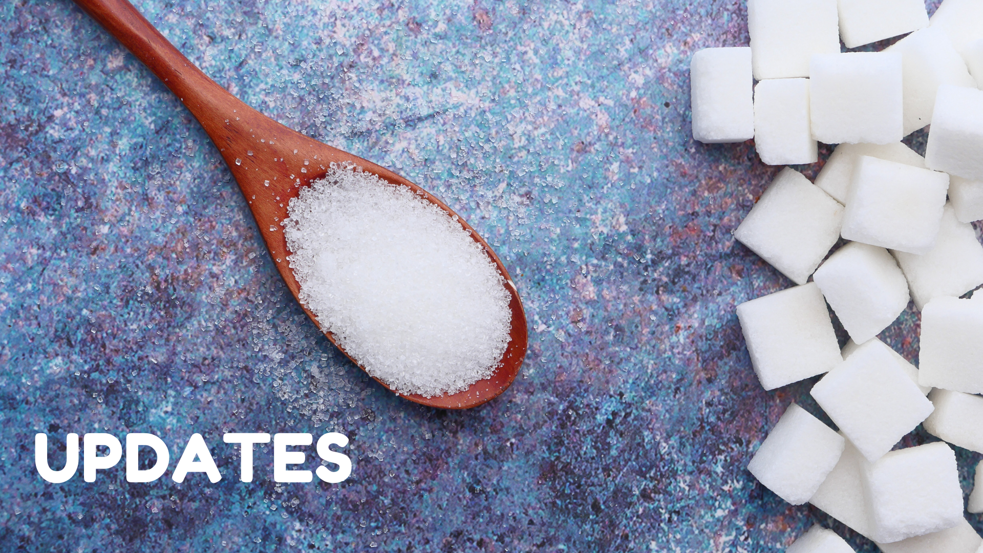 A wooden spoon of white sugar and a pile of sugar cubes with the text "UPDATES".