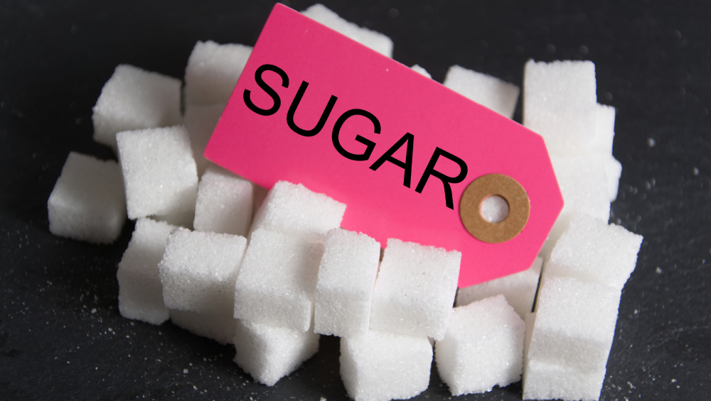 Pile of white sugar cubes with a bright pink price tag labelled "SUGAR".