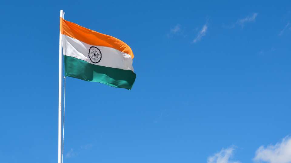 flag of India flying high against a clear blue sky