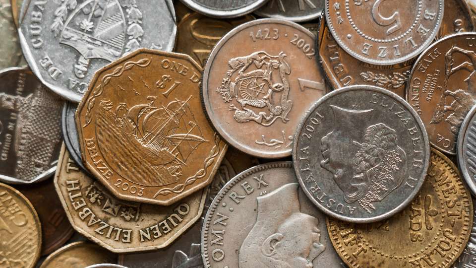 Pile of assorted coins from different countries.