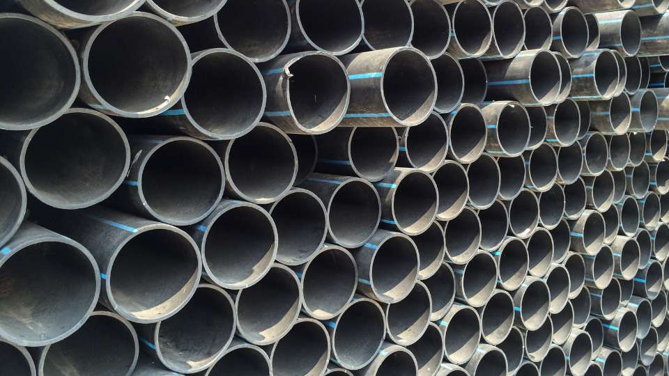 Large stacked industrial pipes arranged in rows for construction or infrastructure use.