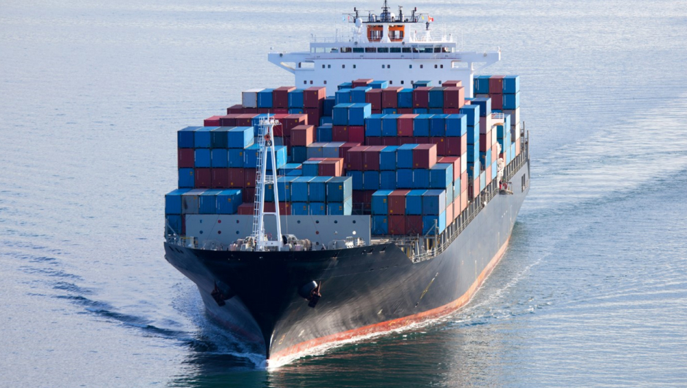 Large container ship sailing forward with stacked cargo containers.