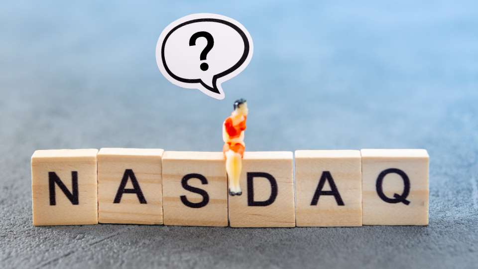 Mini figure sitting on NASDAQ letter blocks with a question mark bubble.