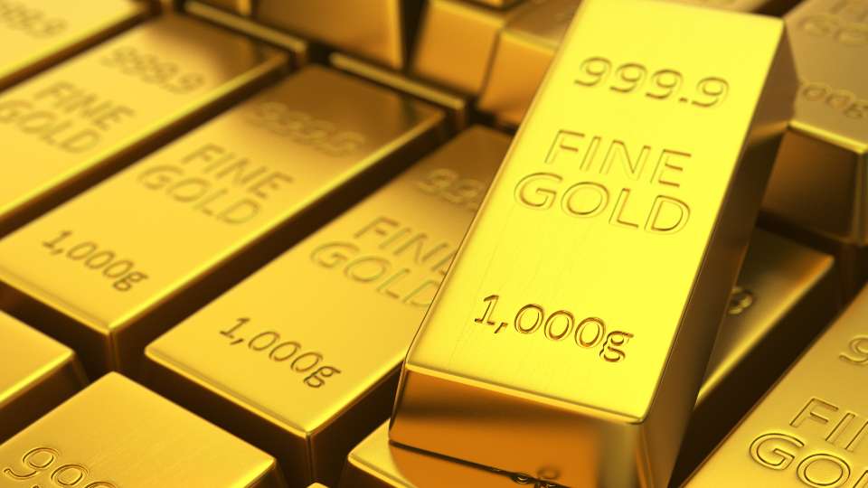 Close-up view of multiple one-kilogram gold bars, stamped with weight and purity (999.9), representing investment gold bullion.