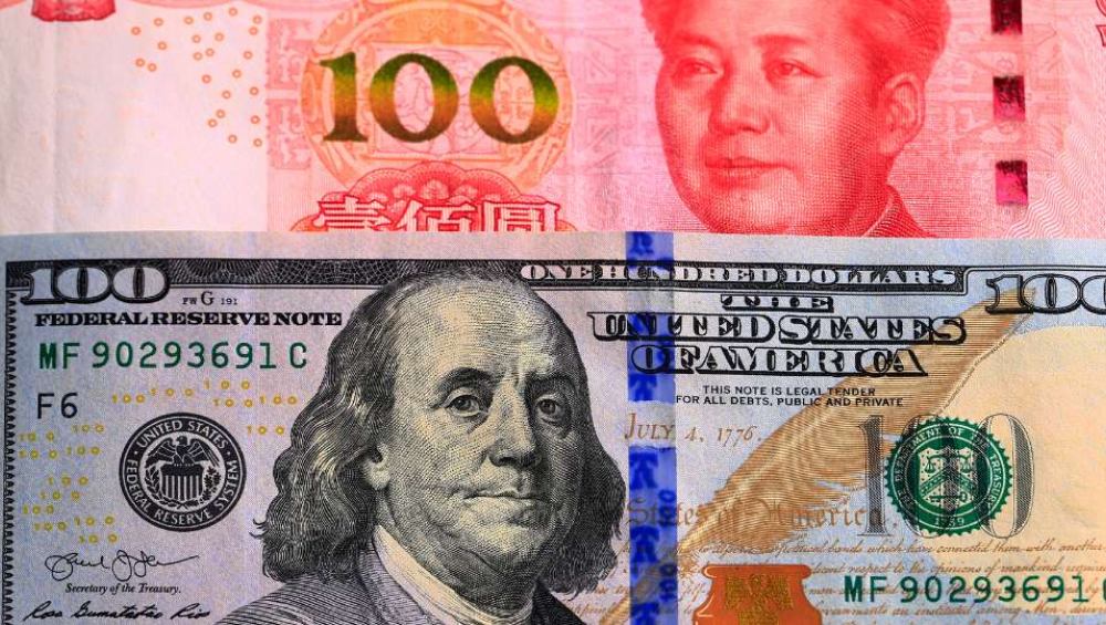 A close-up view showing a US 100-dollar bill overlaid on a Chinese 100-yuan banknote.