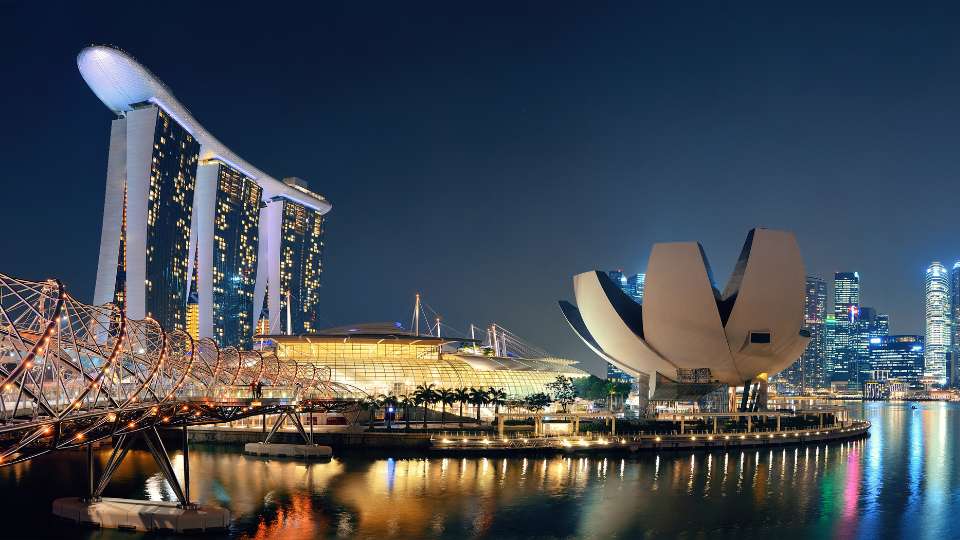 Night-time panoramic view of Singapore's Marina Bay, featuring the Marina Bay Sands hotel and ArtScience Museum.
