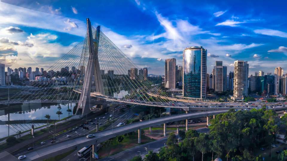 Panoramic view of the São Paulo city skyline featuring the iconic Octavio Frias de Oliveira cable-stayed bridge.