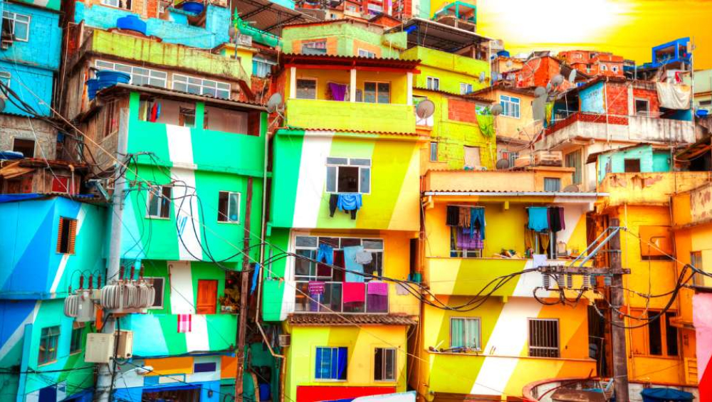 Close-up of densely packed, vibrant, colorfully painted houses in a Brazilian favela under bright sunlight.