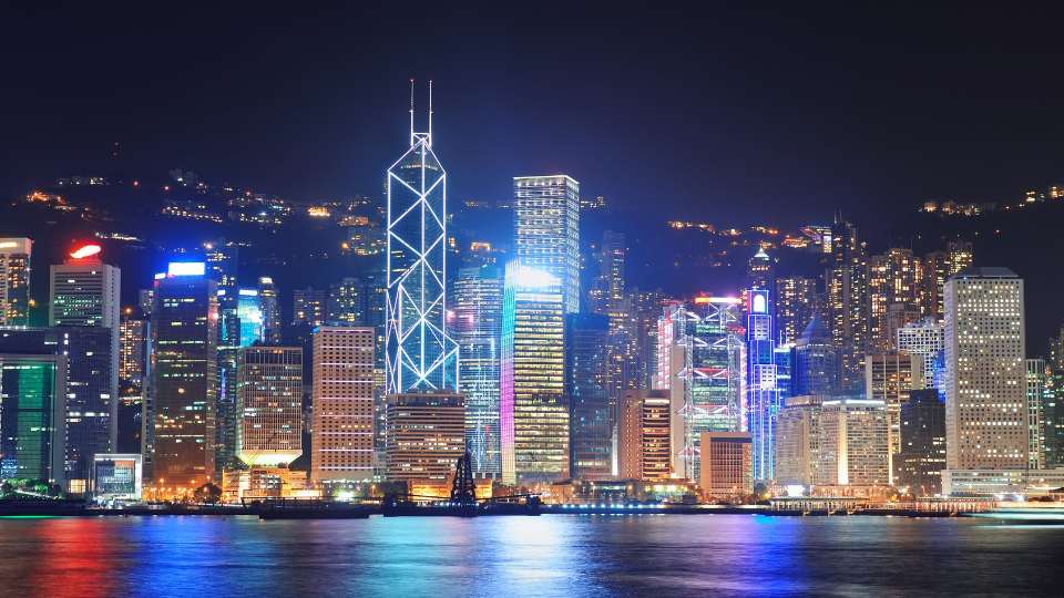 Hong Kong's illuminated skyline and harbor at night, featuring the Bank of China Tower and other skyscrapers