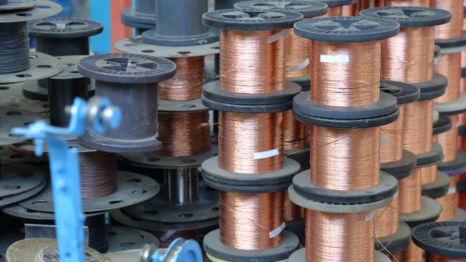 Stacks of copper wire spools in an industrial facility.