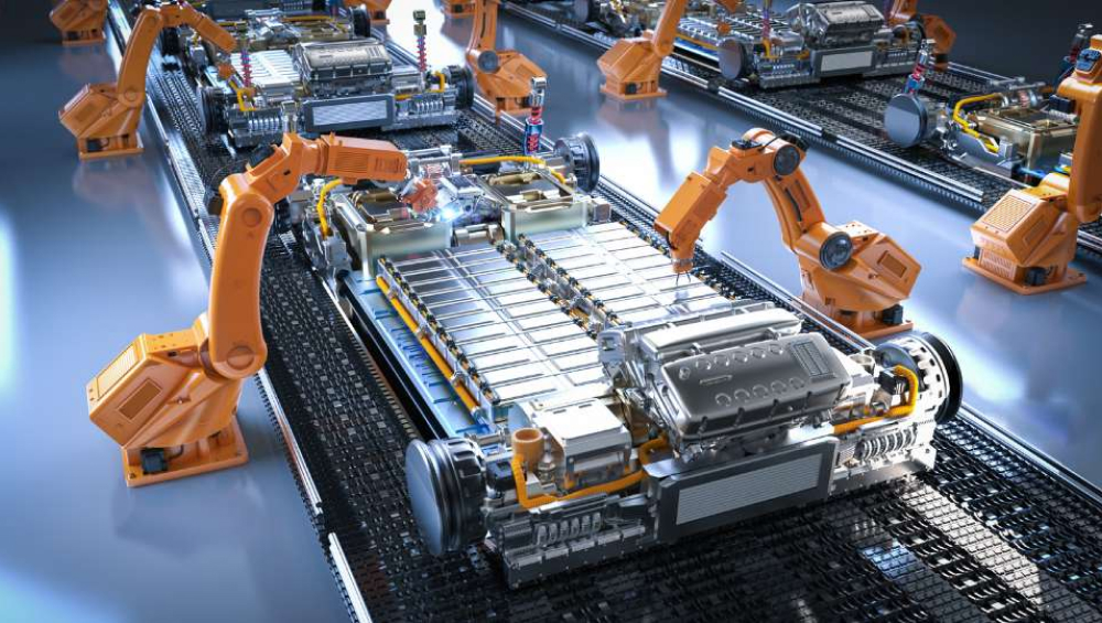 Automated robotic arms assembling electric vehicle battery packs on a production line.