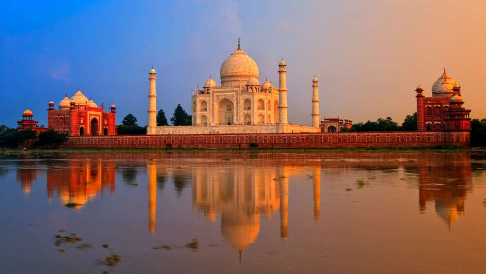 The Taj Mahal in Agra, India, reflecting in the Yamuna River at sunset.