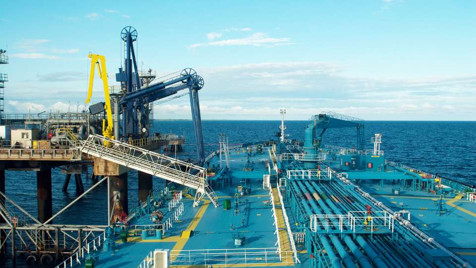 Blue piping systems on the deck of an oil tanker ship at sea.