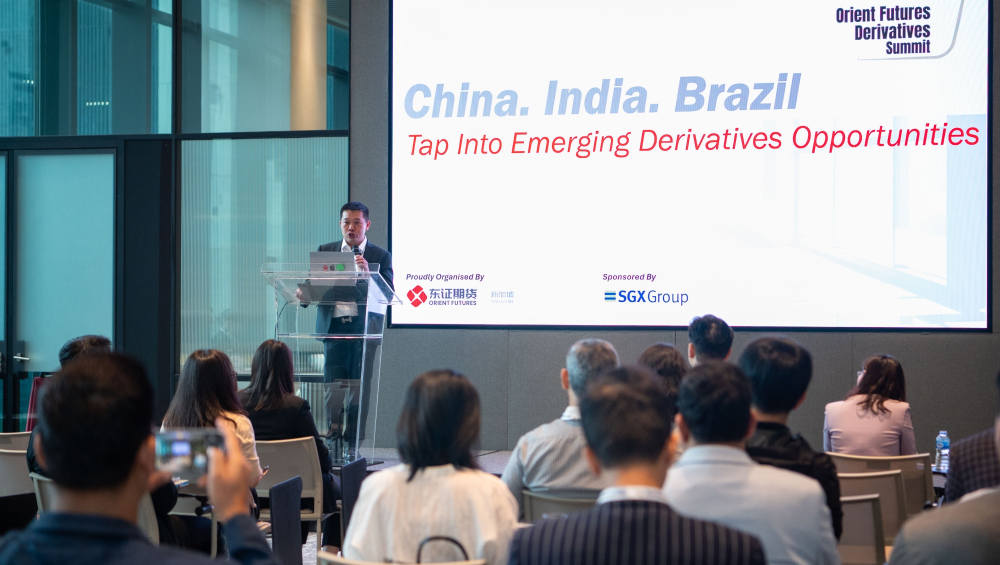 Orient Futures Singapore CEO speaking at Orient Futures Derivatives Summit, with participants visible in foreground
