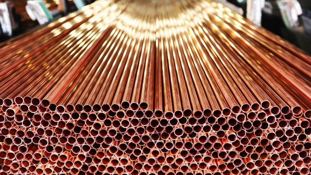 Close-up of stacked shiny copper pipes showing circular ends and long tubes.