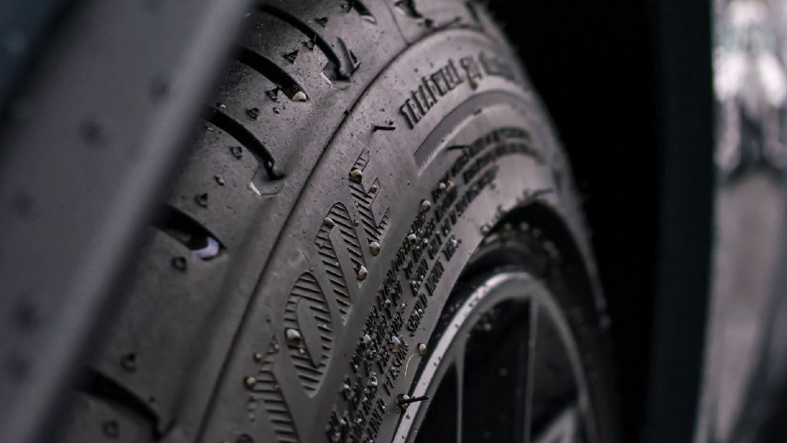 Extreme close-up of a wet car tire sidewall
