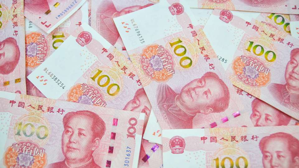 Scattered Chinese renminbi (RMB) notes representing China currency, forex, and financial markets