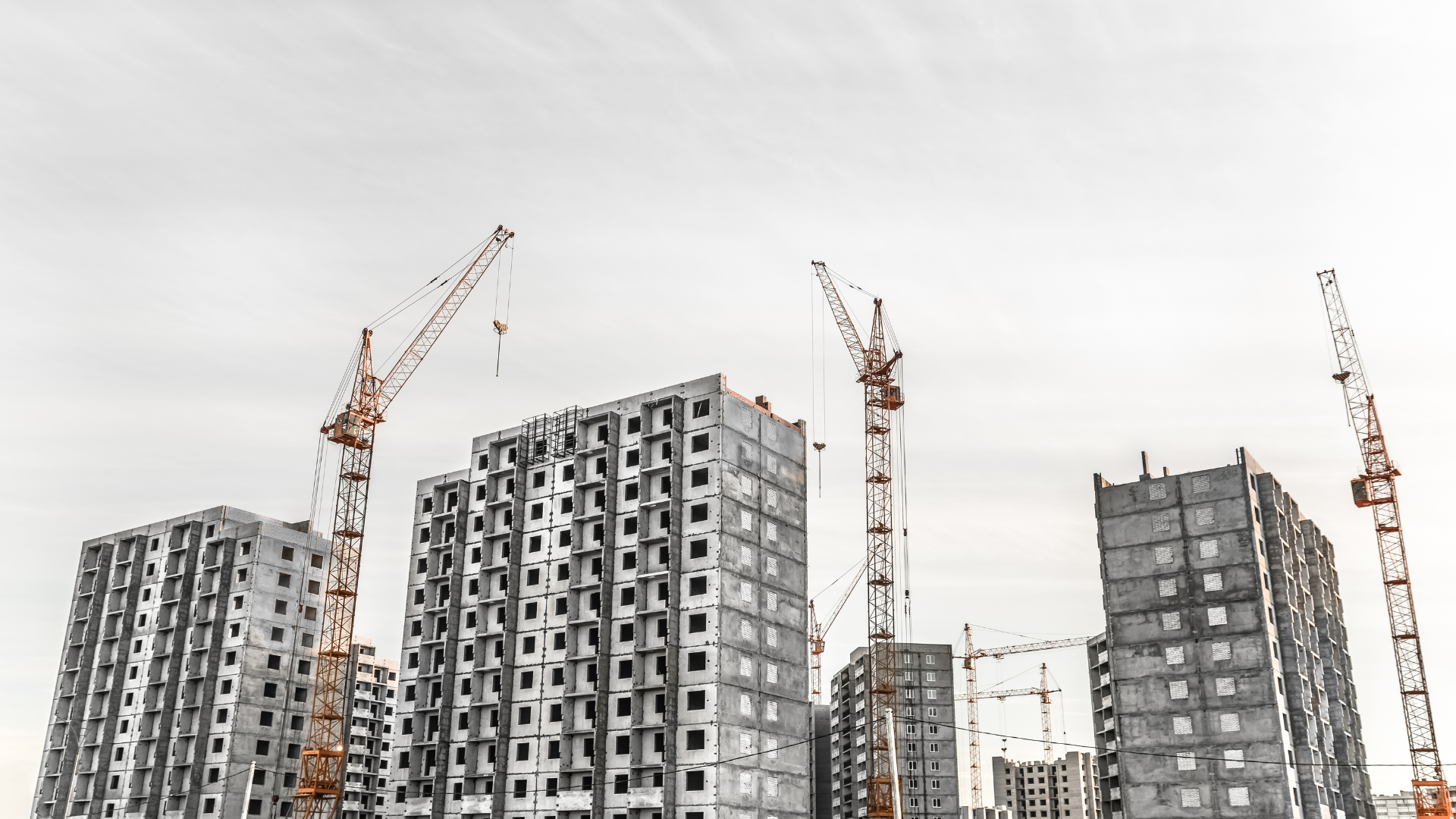 Construction cranes building high-rise apartment complexes.
