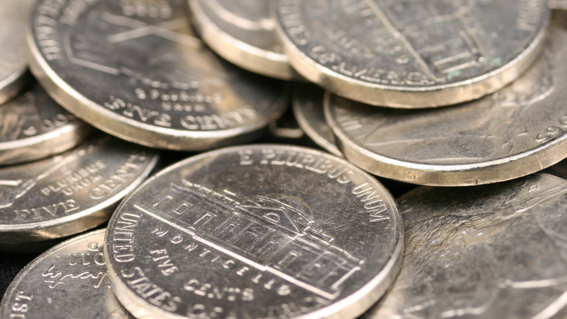 Close-up of stacked U.S. five-cent coins showing Monticello design.
