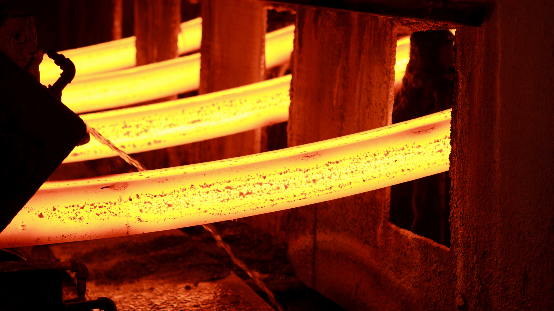 Glowing hot steel bars being cooled in a metal manufacturing process.