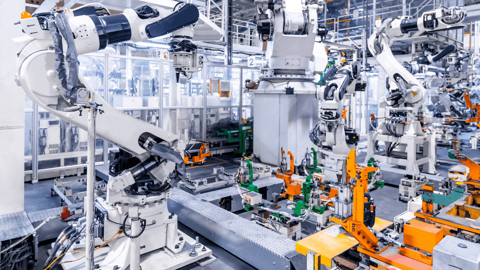 Industrial robotic arms operating on an automated production line in a modern factory.