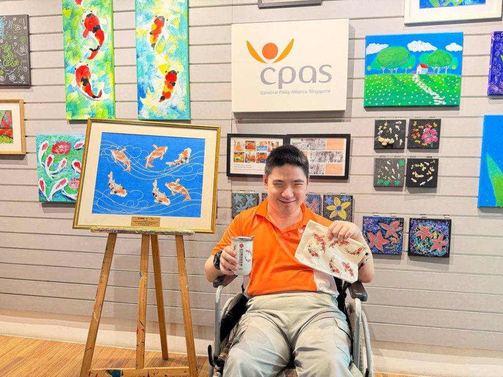 Beneficiary of Cerebral Palsy Alliance Singapore sharing his artwork and artwork-turned-corporate gifts (Koi fish)