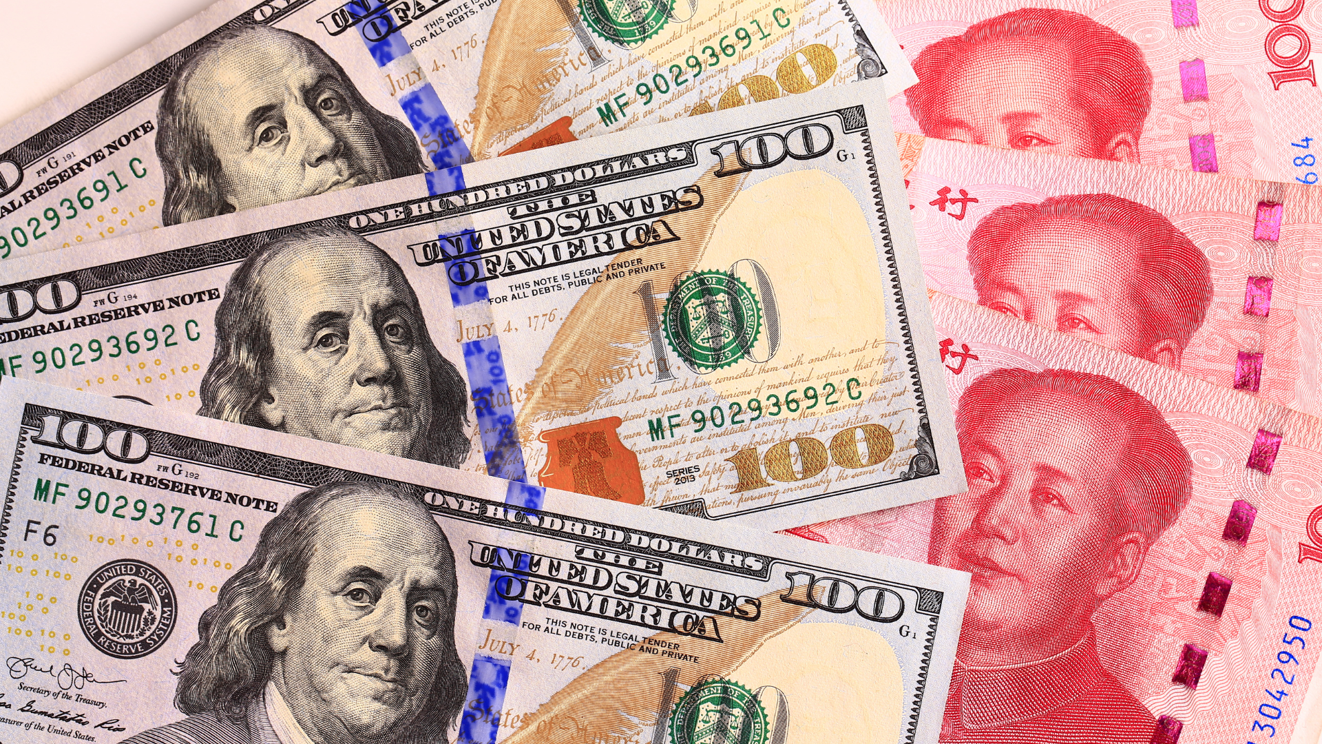 US dollar bills alongside Chinese yuan banknotes representing USD RMB exchange rate