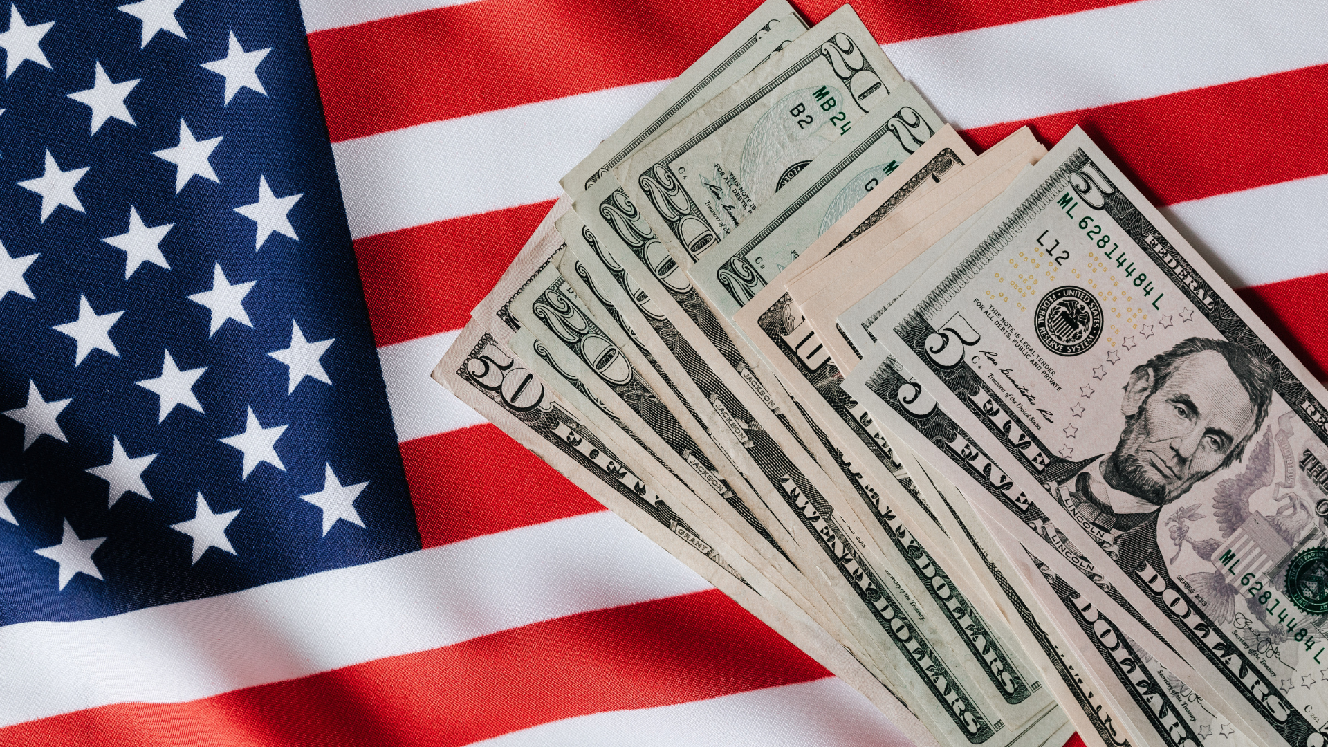 United States flag and pile of dollar bills