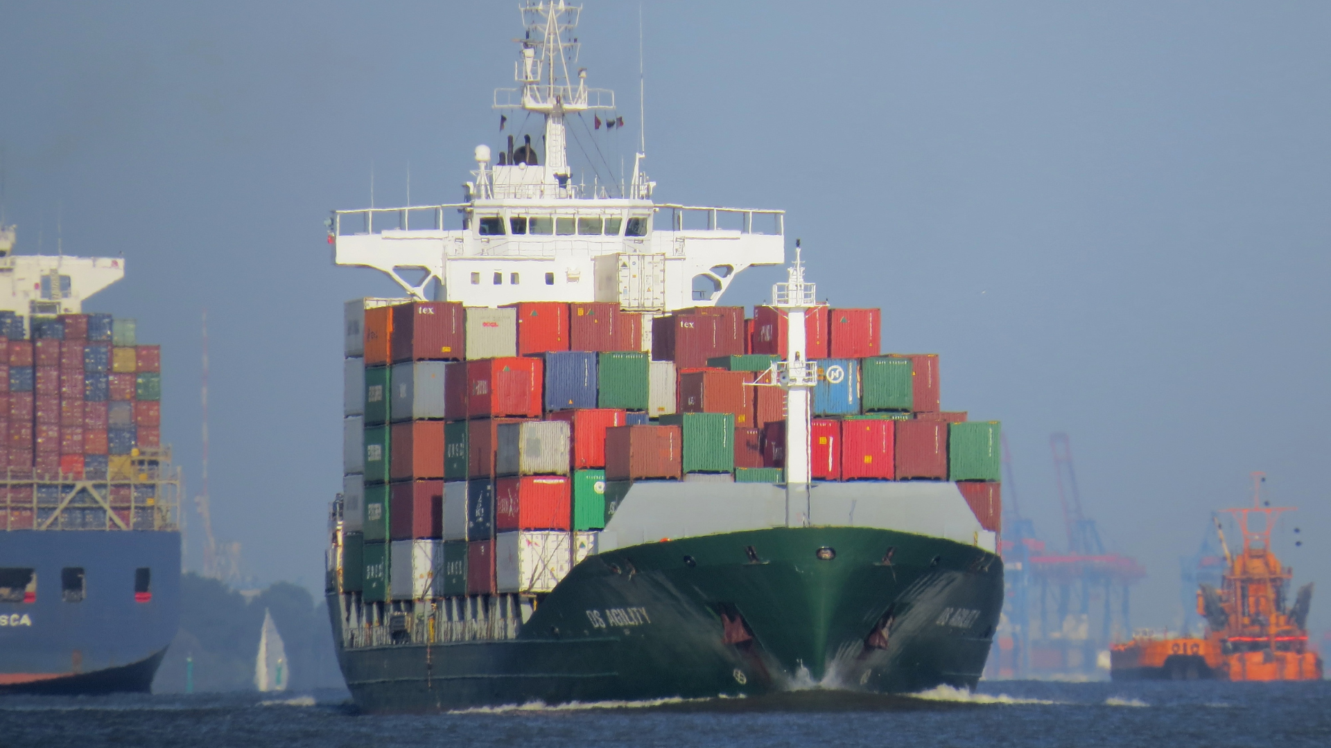 A container ship navigates through a major port