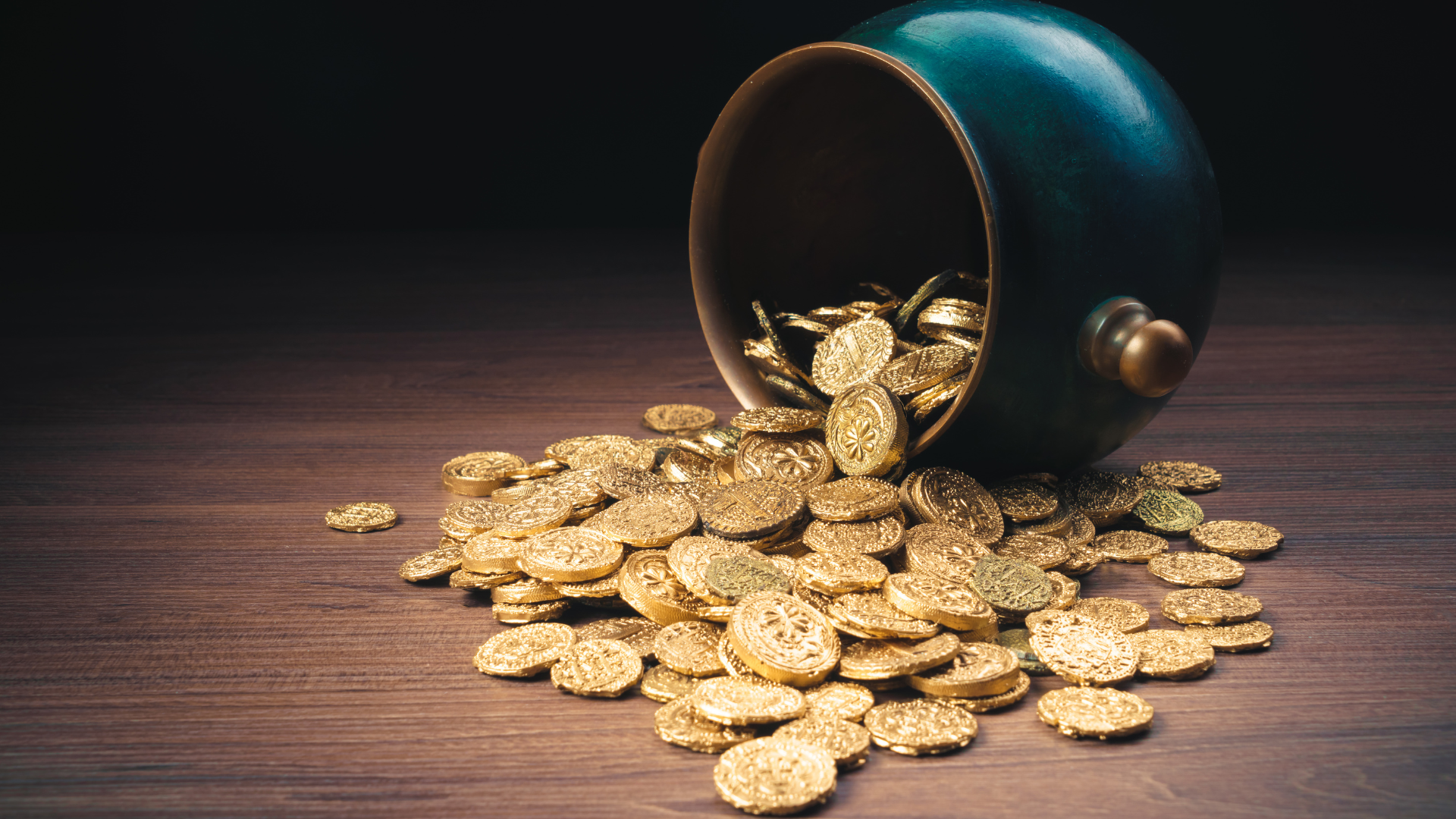 Green pot of gold on top of gold coins