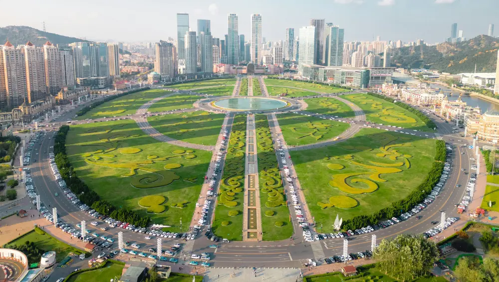an aerial view of xinghai square with green grass dalian